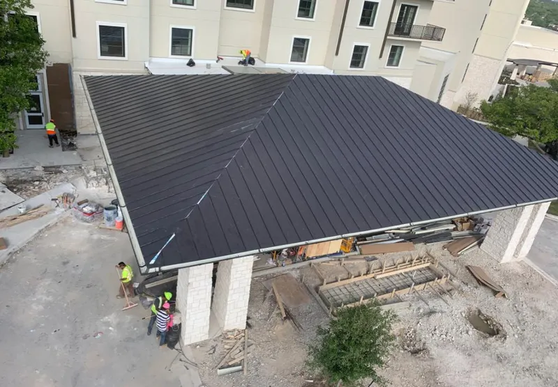 Metal roofing installation team working on a commercial building in Addison
