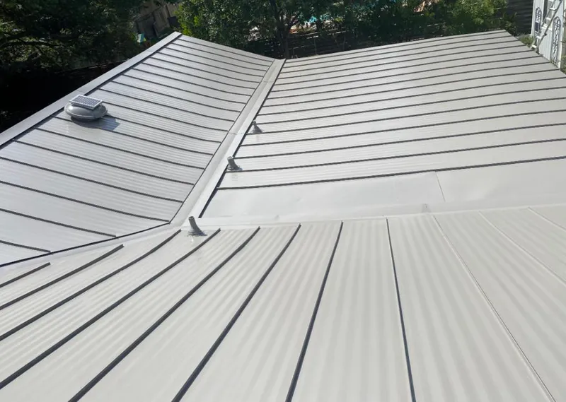 Solar attic fan installed on a metal roof for Roof Ventilation in Addison
